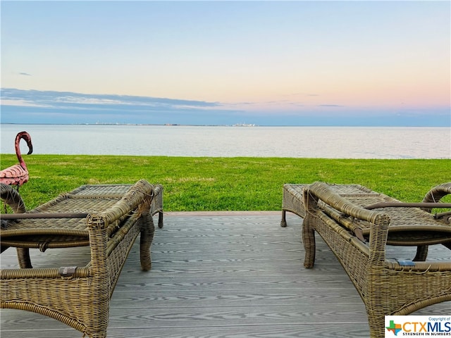 surrounding community with a water view, a lawn, and a dock