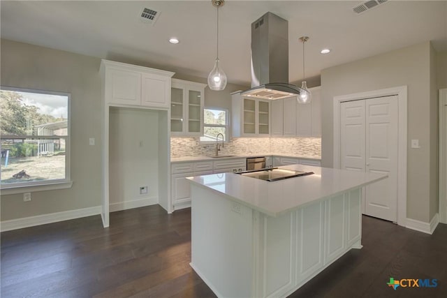 kitchen with white cabinetry, island range hood, a kitchen island, and dark wood-type flooring