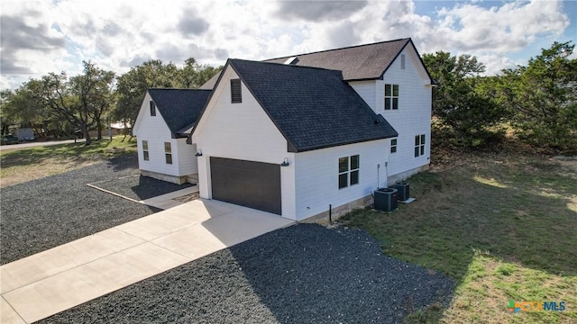 view of home's exterior with a yard, cooling unit, and a garage