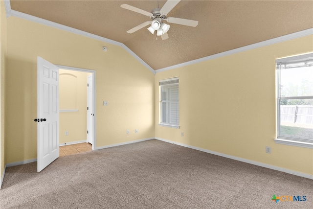 spare room with ceiling fan, lofted ceiling, ornamental molding, and light carpet