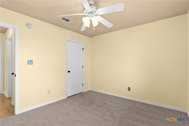 unfurnished bedroom featuring light colored carpet and ceiling fan