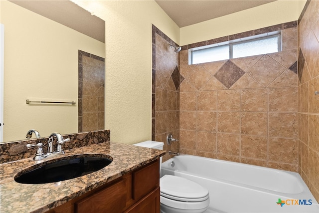 full bathroom featuring tiled shower / bath combo, toilet, and vanity