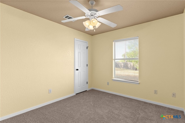 carpeted spare room featuring ceiling fan