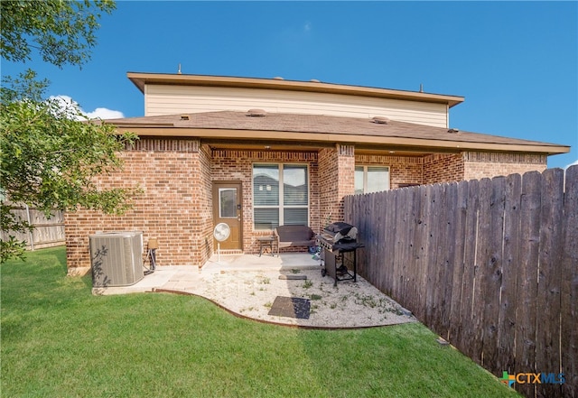 rear view of property featuring central AC, a patio area, and a yard