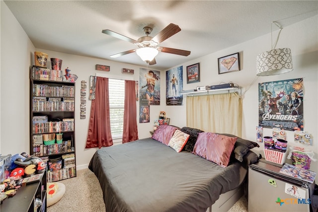 carpeted bedroom with a textured ceiling and ceiling fan