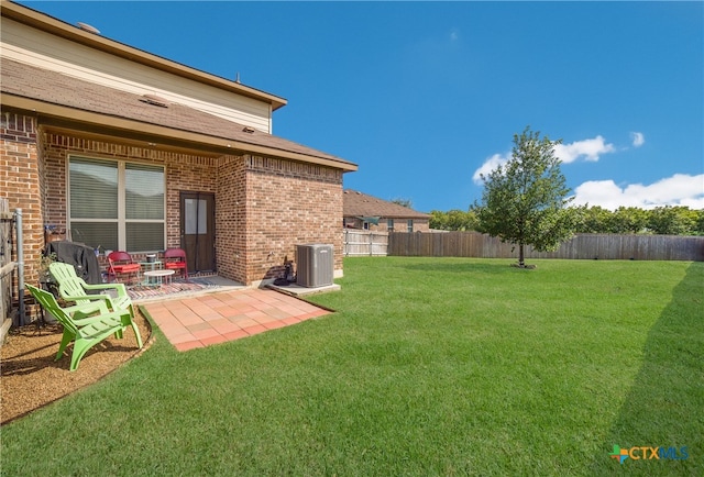 view of yard with central air condition unit and a patio