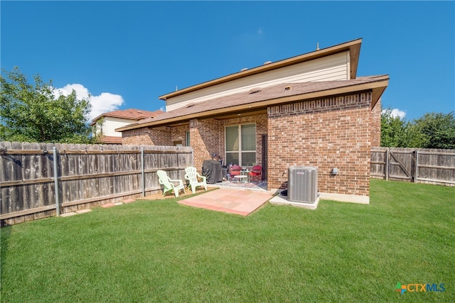 back of property with central air condition unit, a patio area, and a lawn