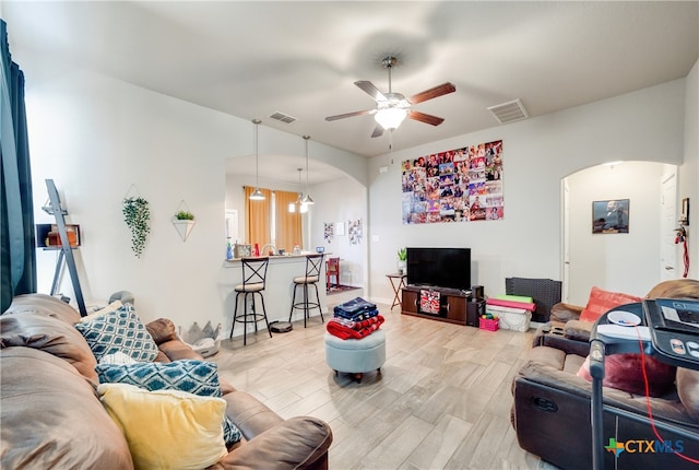 living room featuring wood-type flooring and ceiling fan with notable chandelier