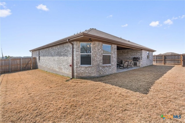 2446 Moreno Spur, Temple, TX 76501 - rear view of property featuring a patio area, a fenced backyard, brick siding, and a yard