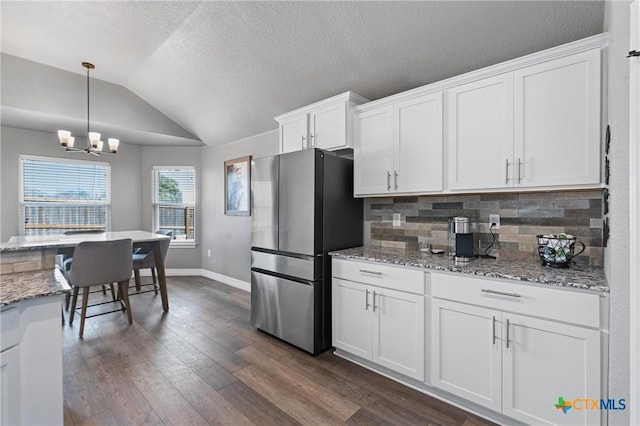 2446 Moreno Spur, Temple, TX 76501 - kitchen featuring decorative backsplash, freestanding refrigerator, dark wood-style flooring, white cabinetry, and a notable chandelier