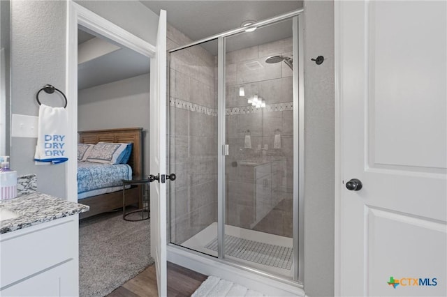 2446 Moreno Spur, Temple, TX 76501 - ensuite bathroom with connected bathroom, vanity, wood finished floors, and a stall shower