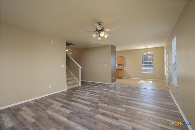 2109 Vernice Dr, Copperas Cove, TX 76522 - unfurnished living room with ceiling fan, stairs, baseboards, and wood finished floors