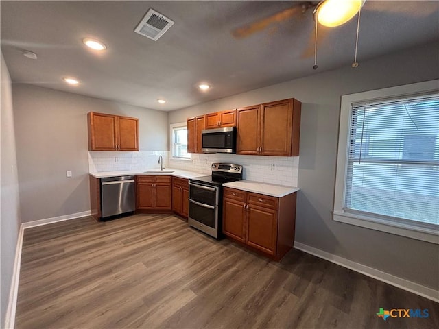 kitchen with tasteful backsplash, sink, dark wood-type flooring, and appliances with stainless steel finishes