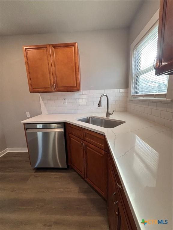 kitchen with dark wood-type flooring, sink, dishwasher, light stone countertops, and backsplash