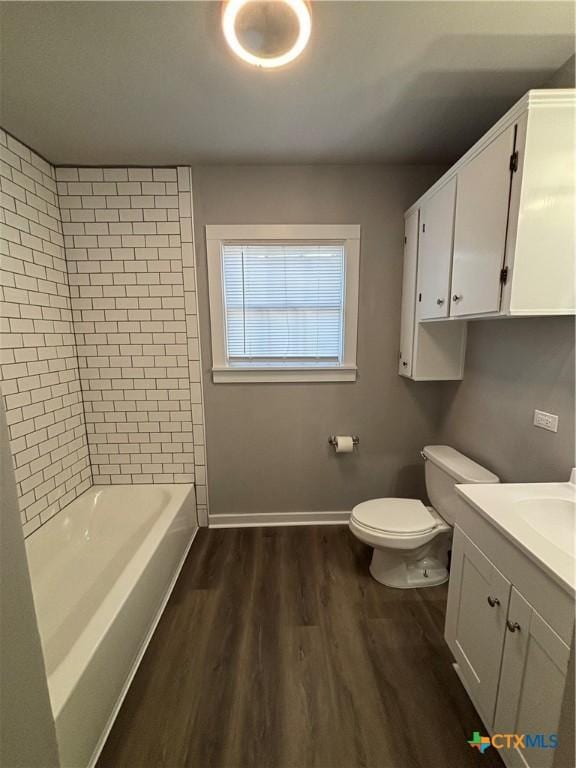 full bathroom with wood-type flooring, toilet, tiled shower / bath combo, and vanity