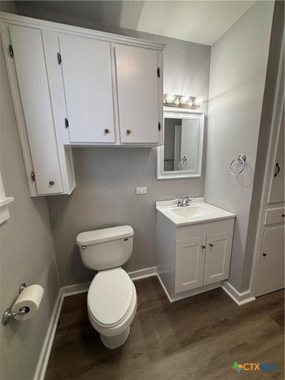 bathroom with hardwood / wood-style flooring, vanity, and toilet