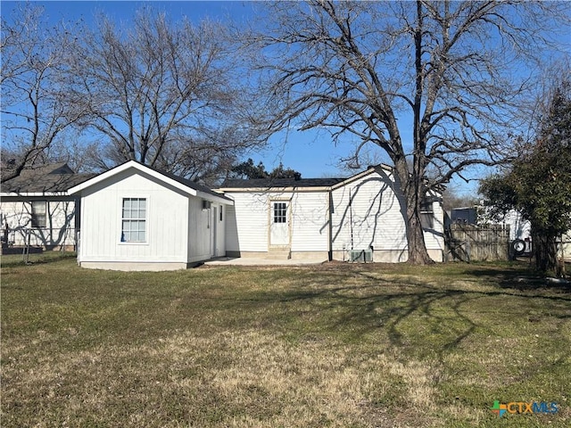 back of property featuring a lawn