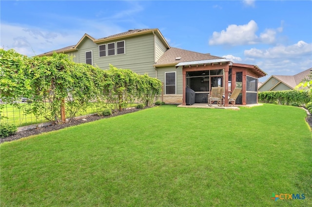 back of house featuring a lawn and a sunroom