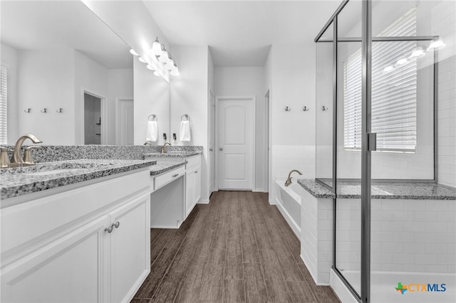 bathroom with vanity, independent shower and bath, and hardwood / wood-style flooring