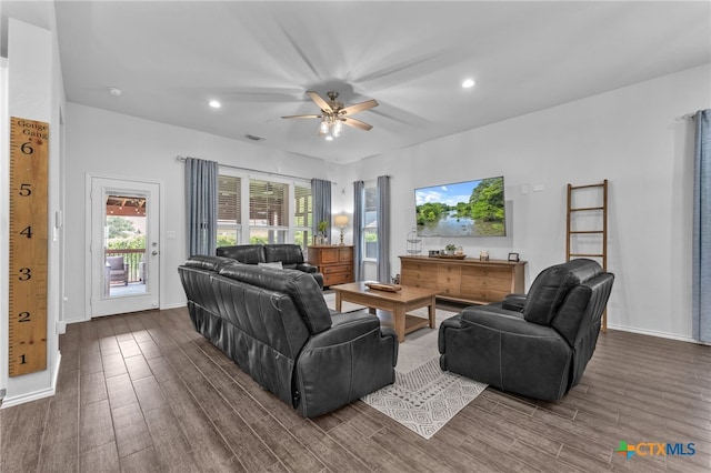 living room with ceiling fan and dark wood-type flooring