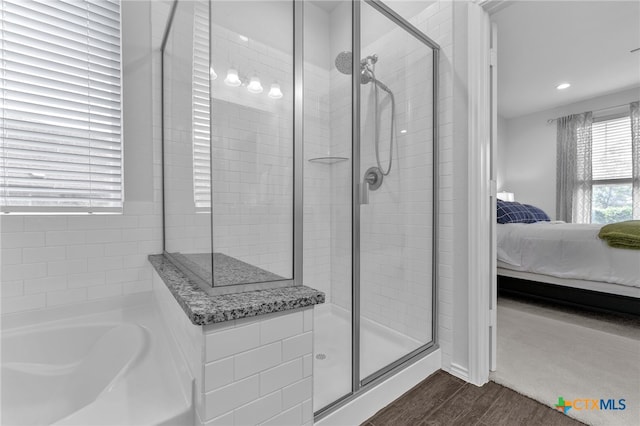 bathroom featuring hardwood / wood-style flooring and independent shower and bath