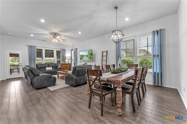 dining space with hardwood / wood-style flooring and ceiling fan with notable chandelier