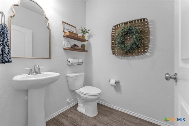 bathroom with sink, toilet, and hardwood / wood-style flooring