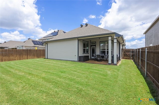 rear view of property featuring a lawn and a patio