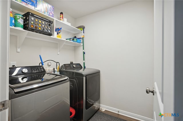 laundry area featuring washing machine and clothes dryer and dark wood-type flooring