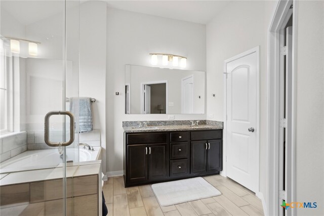 bathroom with hardwood / wood-style floors, a washtub, and vanity