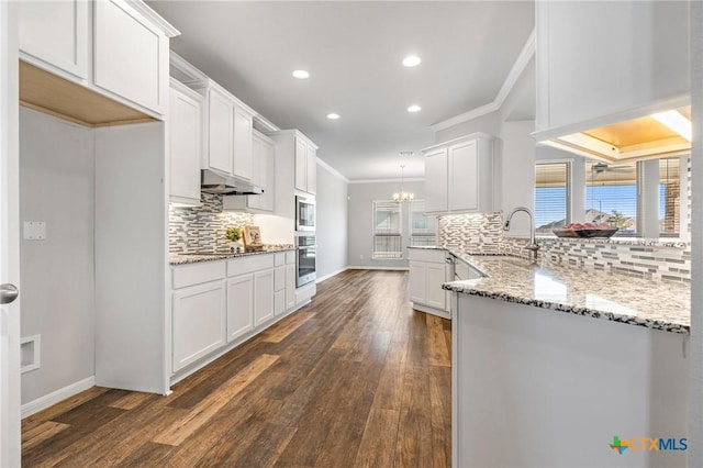 kitchen with sink, dark hardwood / wood-style floors, appliances with stainless steel finishes, white cabinets, and ornamental molding