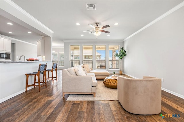 living room with crown molding, ceiling fan, and dark hardwood / wood-style floors