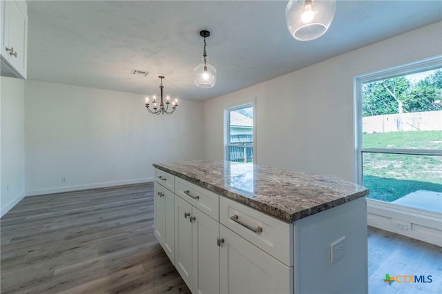 4013 Valley View Dr, Temple, TX 76502 - kitchen featuring light wood-type flooring, a chandelier, healthy amount of natural light, and light stone counters