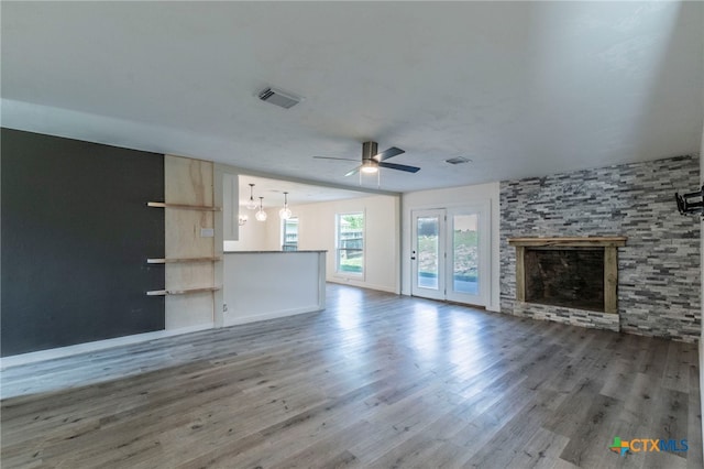 4013 Valley View Dr, Temple, TX 76502 - unfurnished living room with ceiling fan, wood finished floors, a stone fireplace, and baseboards