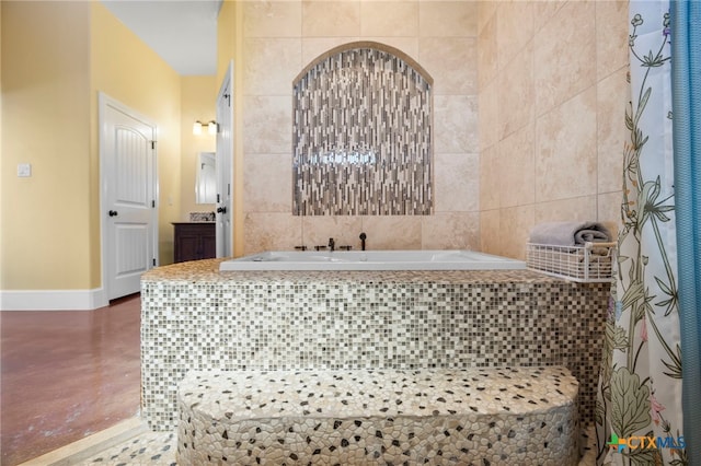 bathroom with vanity and tiled tub