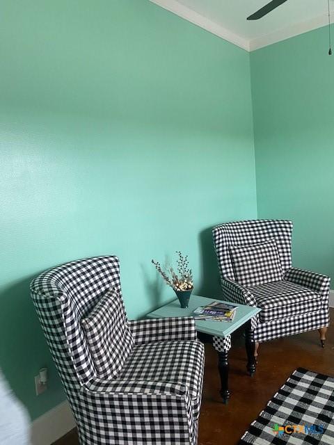 sitting room with crown molding and dark wood-type flooring