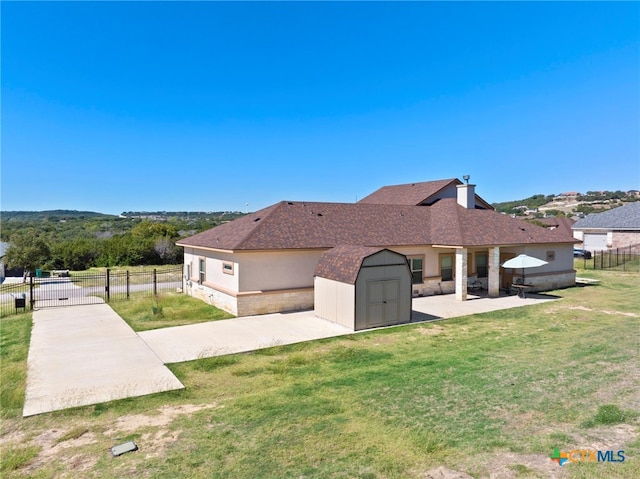 view of side of home with a shed, a lawn, and a patio