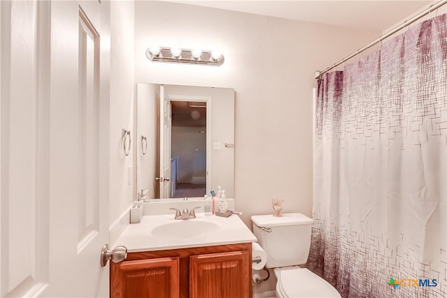 bathroom with walk in shower, vanity, and toilet