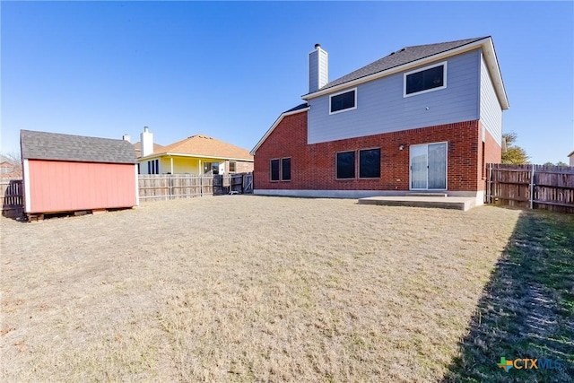 back of property with a storage unit and a patio area