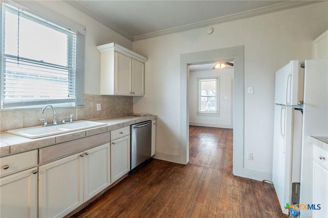 kitchen featuring sink, dishwasher, white cabinetry, white refrigerator, and tasteful backsplash