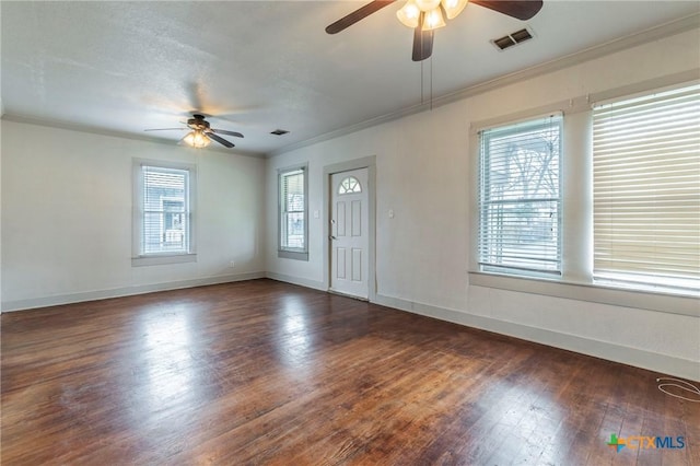 empty room with crown molding, dark hardwood / wood-style floors, and ceiling fan