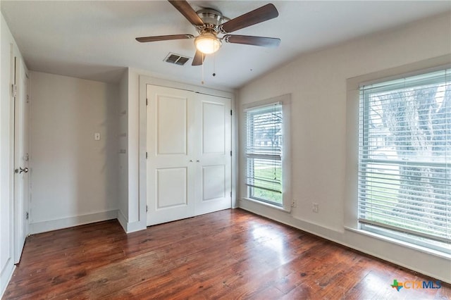 unfurnished bedroom featuring ceiling fan, dark hardwood / wood-style flooring, and a closet