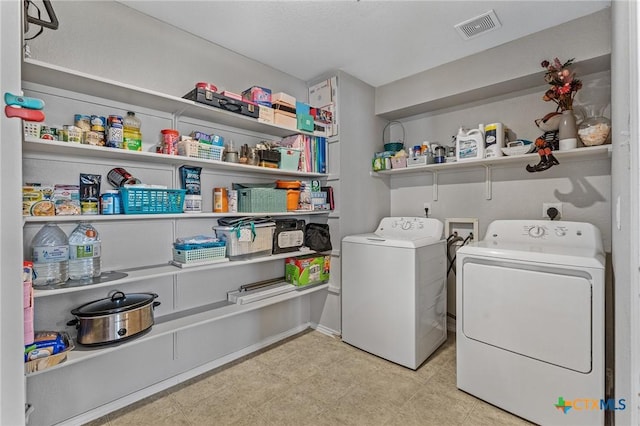 laundry area with laundry area, visible vents, and washing machine and clothes dryer