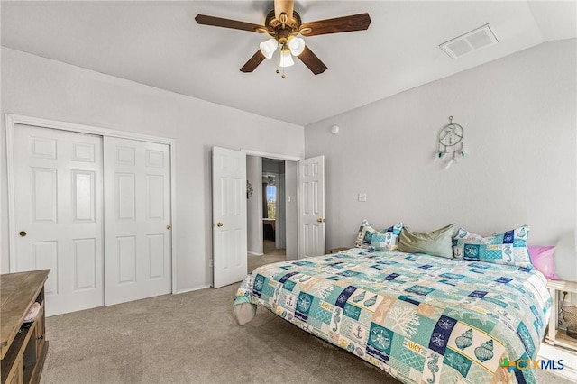 bedroom with light colored carpet, a ceiling fan, visible vents, vaulted ceiling, and a closet