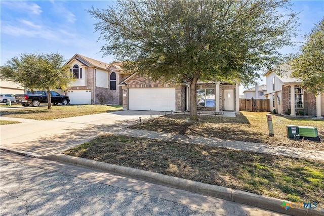 view of property hidden behind natural elements featuring driveway, an attached garage, and fence