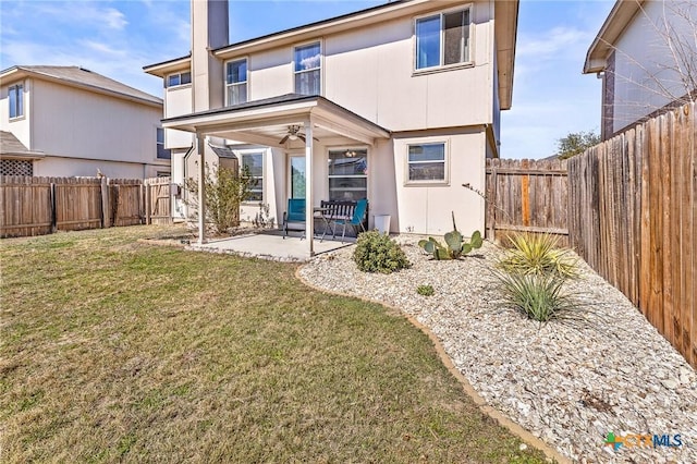 rear view of property featuring a fenced backyard, a yard, and a patio