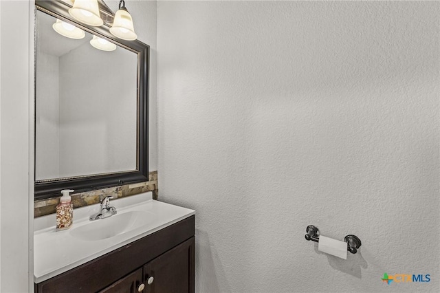 bathroom featuring a textured wall and vanity