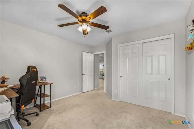 carpeted office space with baseboards, visible vents, and a ceiling fan