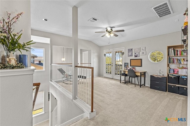 office space with carpet floors, french doors, visible vents, and vaulted ceiling