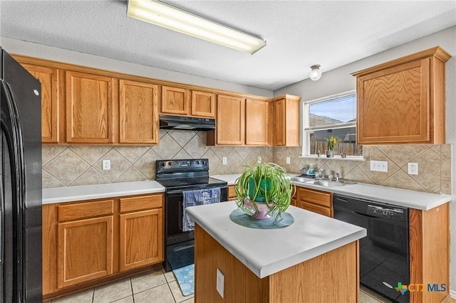 kitchen featuring backsplash, a sink, under cabinet range hood, and black appliances